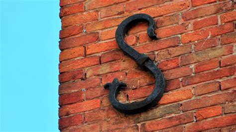 weird little metal flap on side of house|What It Means To See Those Metal Symbols On Brick Houses.